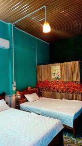 a room with two beds and a green wall at Let's go CAN THO - CAN THO FARMSTAY in Ấp Phú Thạnh (4)