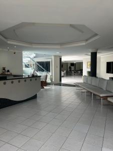 a lobby with couches and tables in a building at Nautillus Hotel in Parnaíba