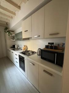 a kitchen with white cabinets and a stove top oven at SanPietro in Verona