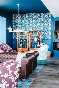 a living room with a couch and blue walls at Hôtel de la Mer in Brignogan-Plage