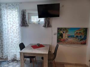 a dining room with a table and a tv on the wall at Zwergenstube in Wülfrath