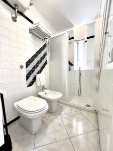 a white bathroom with a toilet and a shower at I Limoni Capri Apartment in Capri