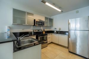 uma cozinha com um frigorífico de aço inoxidável e armários em Fantastic 2BR with balcony in Costa del Este na Cidade do Panamá
