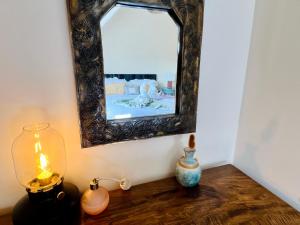 a mirror on a wall above a table with vases at Top floor double en-suite BR apartment central Matlock in Matlock