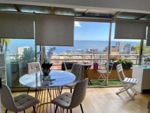 PANORAMIC MONACO VIEW, BnbRickeys في بوسولاي: غرفة مع طاولة وكراسي وإطلالة على المحيط