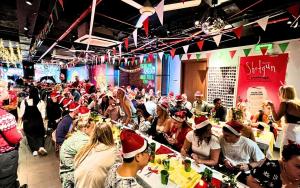 a crowd of people wearing christmas hats in a room at Mad Monkey Hanoi in Hanoi