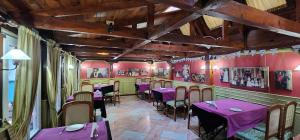 a restaurant with purple tables and chairs in a room at Hotel London in Tirana