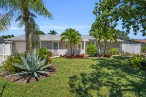 a house with palm trees in a yard at Naples Single Family Pool Home - Kayak the Gordon River & Be Close to the Beach! in Naples