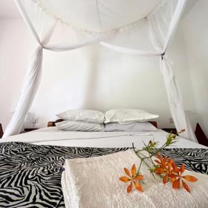 een slaapkamer met een bed met zebraprint en een baldakijn bij Mama Pierina Restaurant and Annex in Morogoro