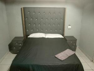 a bed with a large headboard in a room at Streetview Suites in Polokwane