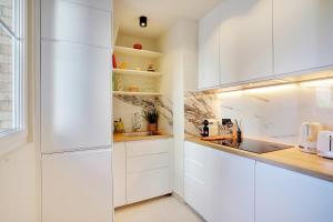 una cocina blanca con armarios blancos y fregadero en Luxury flat silly - Boulogne city center, en Boulogne-Billancourt