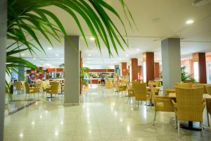 a restaurant with chairs and tables in a building at ALEGRIA Fenix Family in Roquetas de Mar