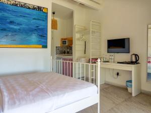a bedroom with a bed and a desk and a tv at Oza Boutique hotel in Gümüşlük
