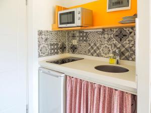 a kitchen with a sink and a microwave at Oza Boutique hotel in Gümüşlük