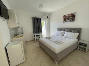 Joni Apartments في كساميل: غرفة نوم صغيرة بها سرير ومغسلة