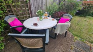 a table and chairs with pink pillows on a patio at Sticky Wicket by Spires Accommodation a comfortable place to stay in Swadlincote in Church Gresley