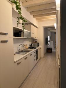kuchnia z białymi szafkami i zlewem w obiekcie SanPietro w Weronie