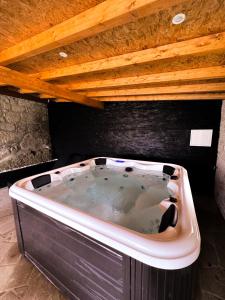 eine große Badewanne unter einer Holzdecke in der Unterkunft DreamVille - Casa da Tapada in Arcos de Valdevez