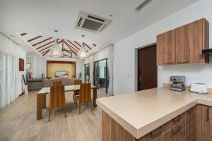 a kitchen and living room with a table and chairs at VILLA BOND| 3 Bedrooms | Private Pool | 3 min to Naiharn Beach in Rawai Beach