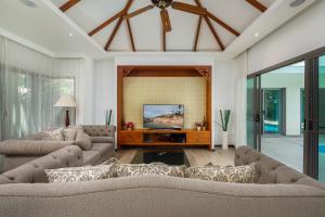 a living room with two couches and a tv at VILLA BOND| 3 Bedrooms | Private Pool | 3 min to Naiharn Beach in Rawai Beach