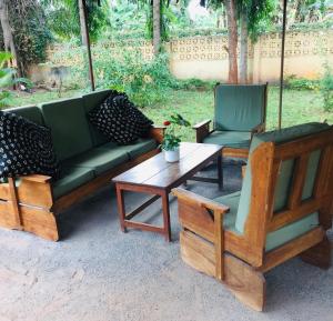 twee stoelen en een bank en een tafel bij Mama Pierina Restaurant and Annex in Morogoro