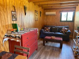a living room with a red dresser and a couch at Preciosa Casa de Madera, Andalucía in Prado del Rey