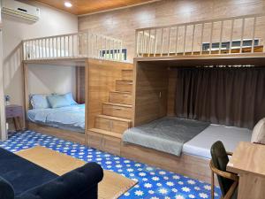 LỌ LEM CINDERELLA HOMESTAY في فينه لونج: غرفة نوم مع سريرين بطابقين وأريكة