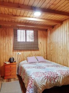 a bedroom with a bed in a wooden room at Preciosa Casa de Madera, Andalucía in Prado del Rey
