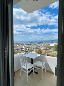 a table and chairs on a balcony with a view at Joni Apartments in Ksamil
