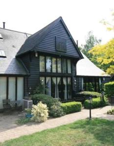 une maison noire avec un toit noir dans l'établissement BARN: Sleeps 6, Stansted 12 mins, à Hatfield Broad Oak