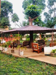 a gazebo with chairs and tables and a tree at Mama Pierina Restaurant and Annex in Morogoro