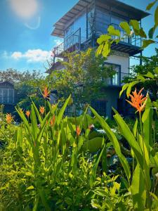 a house on a hill with flowers in the foreground at LỌ LEM CINDERELLA HOMESTAY in Vĩnh Long