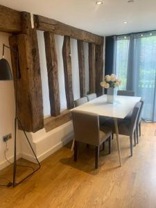 a dining room table with chairs and a vase of flowers at BARN: Sleeps 6, Stansted 12 mins in Hatfield Broad Oak