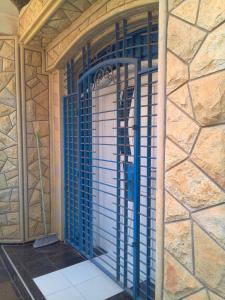 une porte avec des barres bleues dans un bâtiment en pierre dans l'établissement Maison d'Hôte à Saïdia, à Saïdia