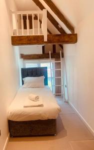 a bedroom with a bunk bed with a ladder at BARN: Sleeps 6, Stansted 12 mins in Hatfield Broad Oak