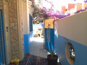a narrow alley with a blue door and a plant at Maison d'Hôte à Saïdia in Saidia 