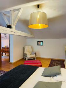 ein Wohnzimmer mit einem Bett und einem Stuhl in der Unterkunft Suite familiale à la campagne in Sauveterre