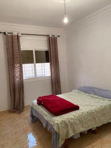 a bedroom with a bed and a window at Appartement familial a lmriss in Oulad Zenati