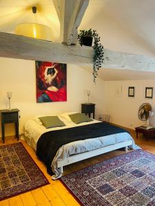 ein Schlafzimmer mit einem Bett und einem Wandgemälde in der Unterkunft Suite familiale à la campagne in Sauveterre