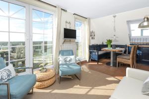 Una sala de estar con un sofá y sillas y una mesa. en Haus Sanderling Spinnaker16, en Juist