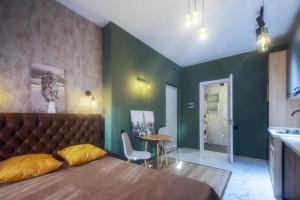 a bedroom with a bed and a table and a kitchen at A-Y Apartments P A4 in Tbilisi City