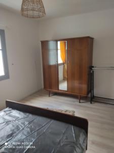 a bedroom with a wooden dresser and a mirror at gite 4 pers a ROUZE in Rouze