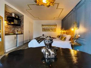 a bedroom with a bed and a statue on a table at Le Marquis Petit cocon chic et fonctionnel in Saverne