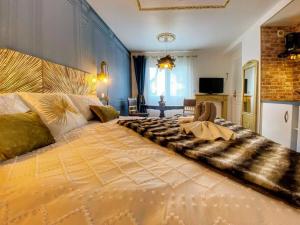 a large bedroom with a large bed with a large bedspread at Le Marquis Petit cocon chic et fonctionnel in Saverne