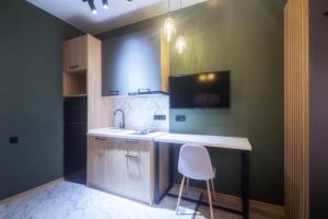 een keuken met een aanrecht en een stoel. bij A-Y Apartments P A4 in Tbilisi City