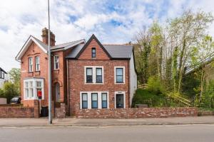 a brick house on the side of a street at The Old Kiosk - Luxe 4 Bed House - Roath Park in Cardiff