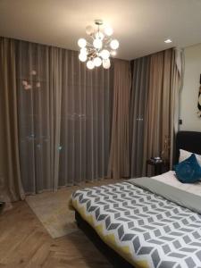 una camera con un grande letto e un lampadario a braccio di Era View Bahrain Luxurious 1 bedroom, Sea view and waterfront a Manama