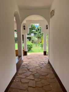 an empty hallway with a stone floor and an archway at Mama Pierina Restaurant and Annex in Morogoro