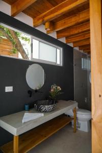 une salle de bain avec un lavabo et un miroir et des toilettes dans l'établissement Villa SOL, à Santa Teresa
