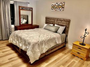 1 dormitorio con 1 cama con mesita de noche y espejo en Modern Vac Home, private Hot tub, close to airport, Dieppe, Moncton en Dieppe
